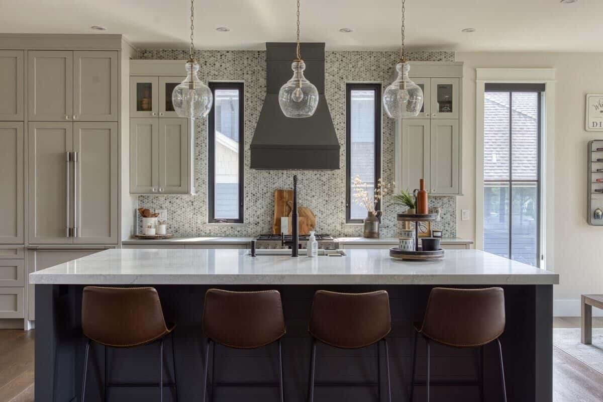 Kitchen with white cabinets and a breakfast island with seating for four.