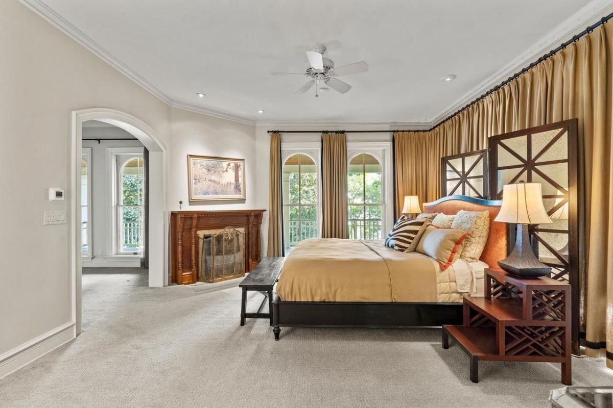 Bedroom with carpet flooring, a ceiling fan, custom lighting, and glass windows.