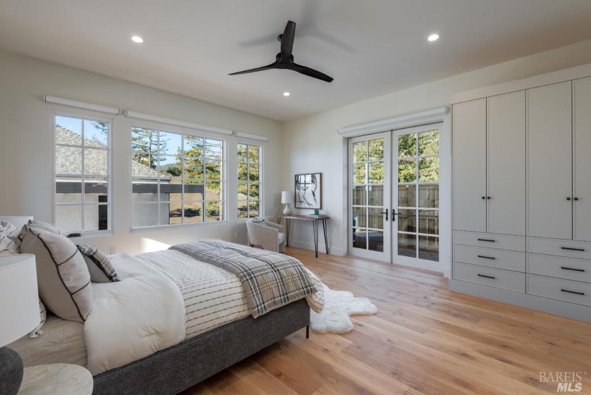 Bedroom with wood flooring and custom lights.