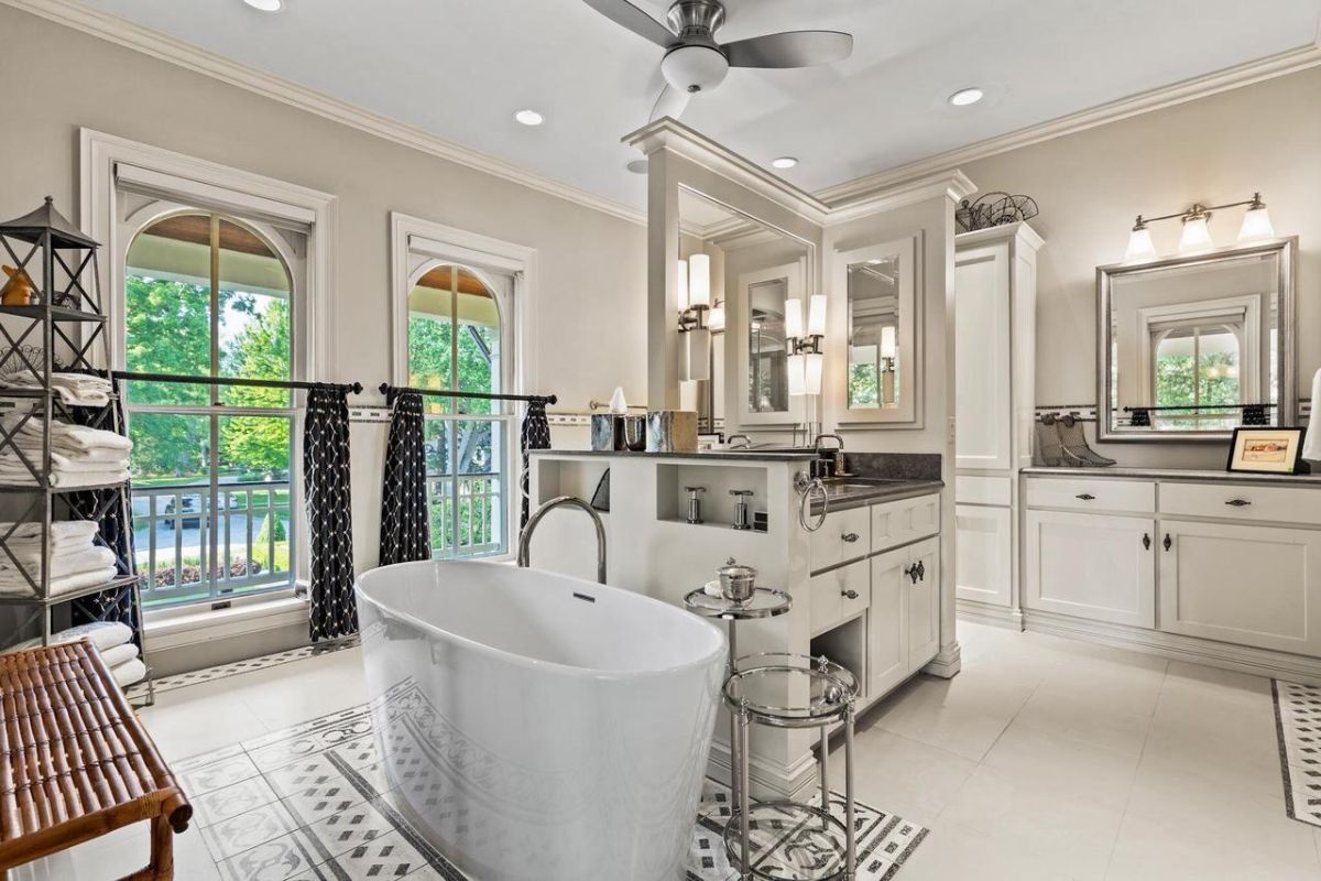 Bathroom with custom cabinetry, a large tub and a sink.