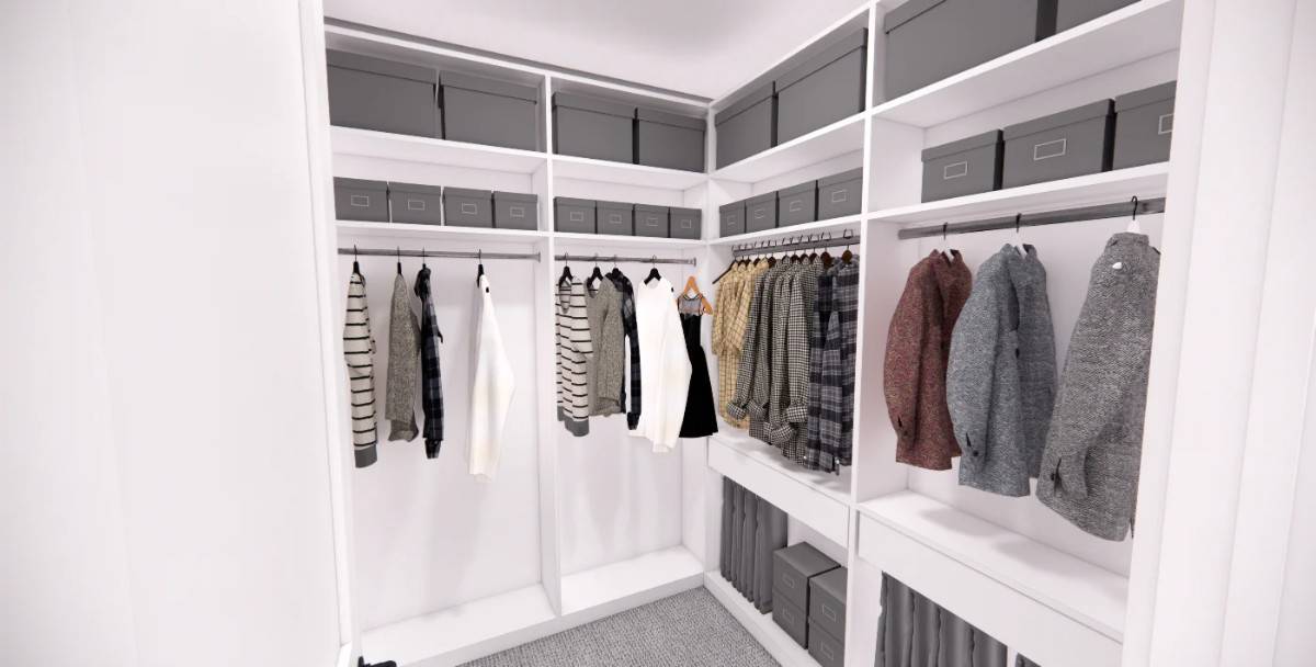 Primary walk-in closet with white built-ins and a carpeted floor.