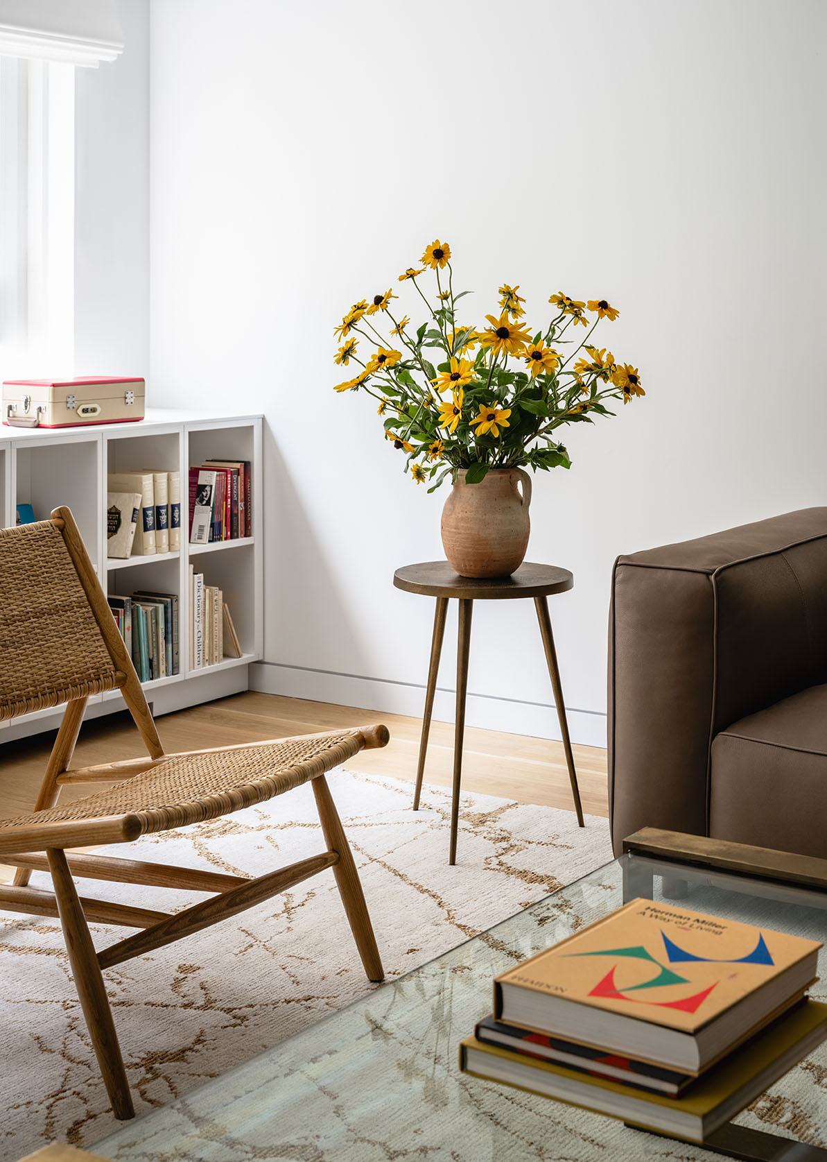 Side table with flowers next to mid-century sofa and accent chairs in renovated 2,500 sq ft mid-century modern apartment