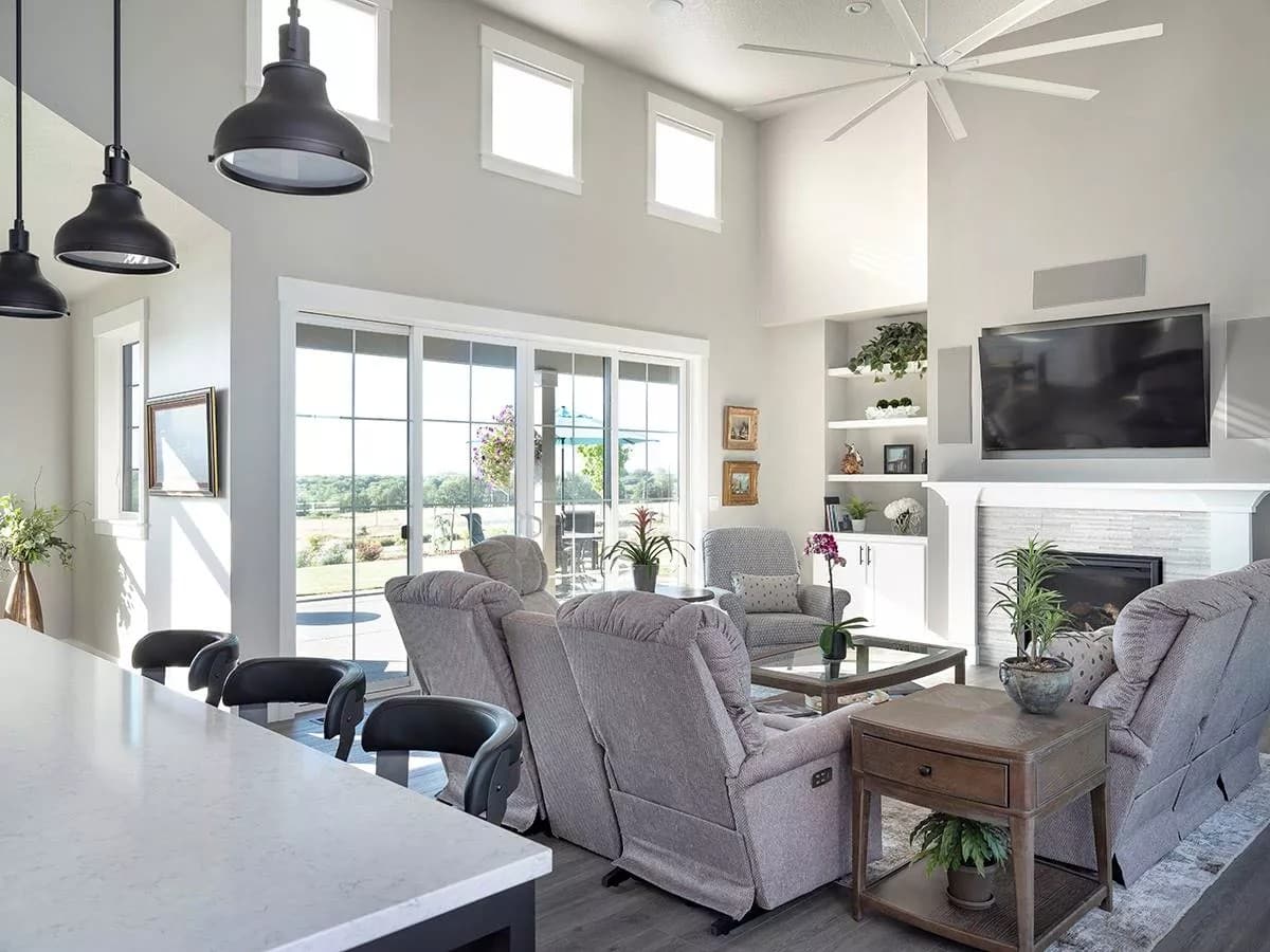 Great room with gray sofas and a fireplace with a TV on top.