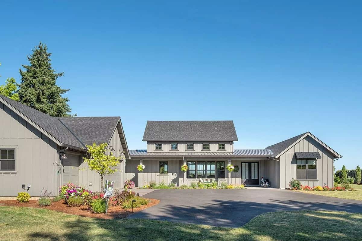 Front view with a side-entry garage and an expansive front porch topped with a large dormer.