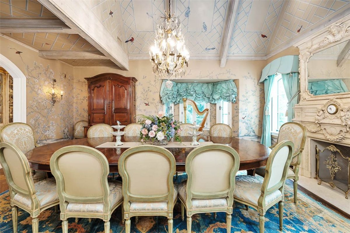 Dining room with a chandelier and a large table. 