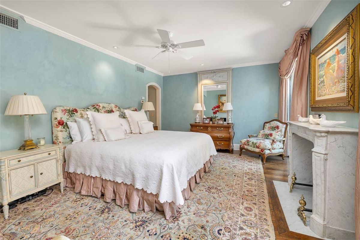 Bedroom with a large bed and a fireplace.