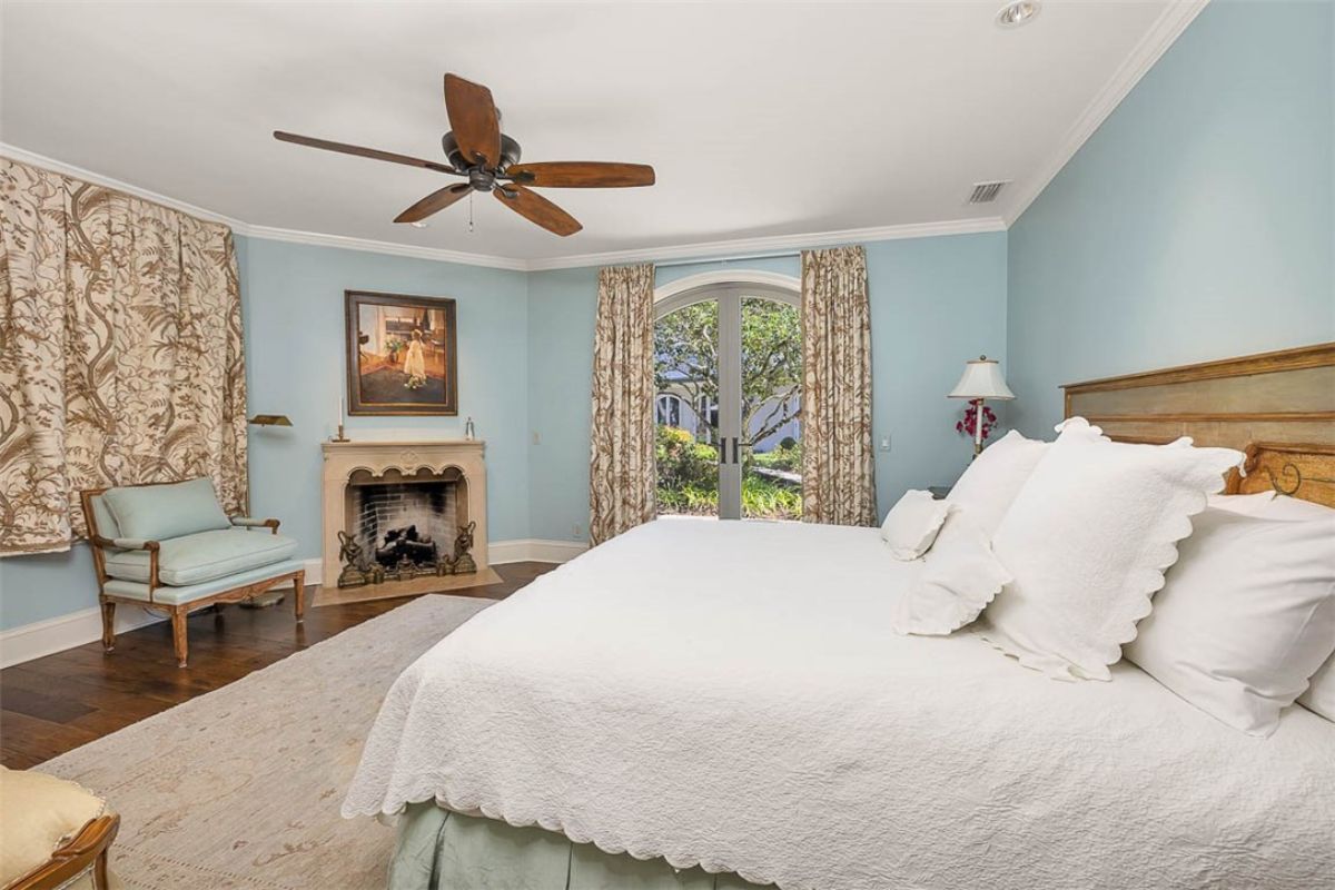 Bedroom with a large bed and a fireplace.