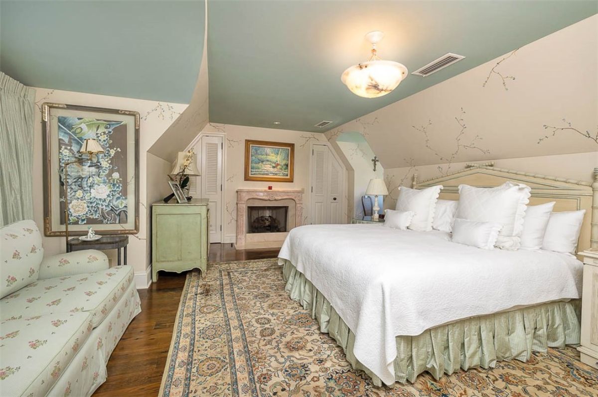 Bedroom with a large bed and a fireplace.