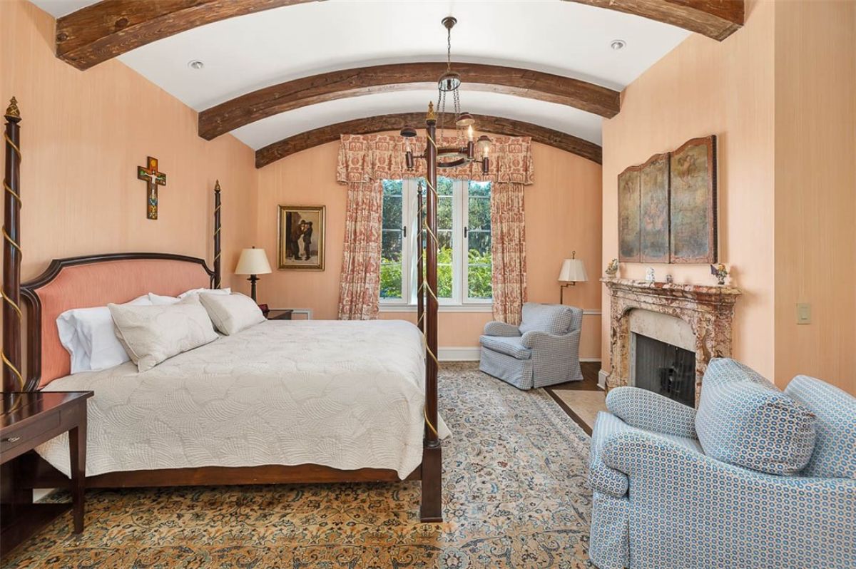 Bedroom with a large bed and a fireplace.