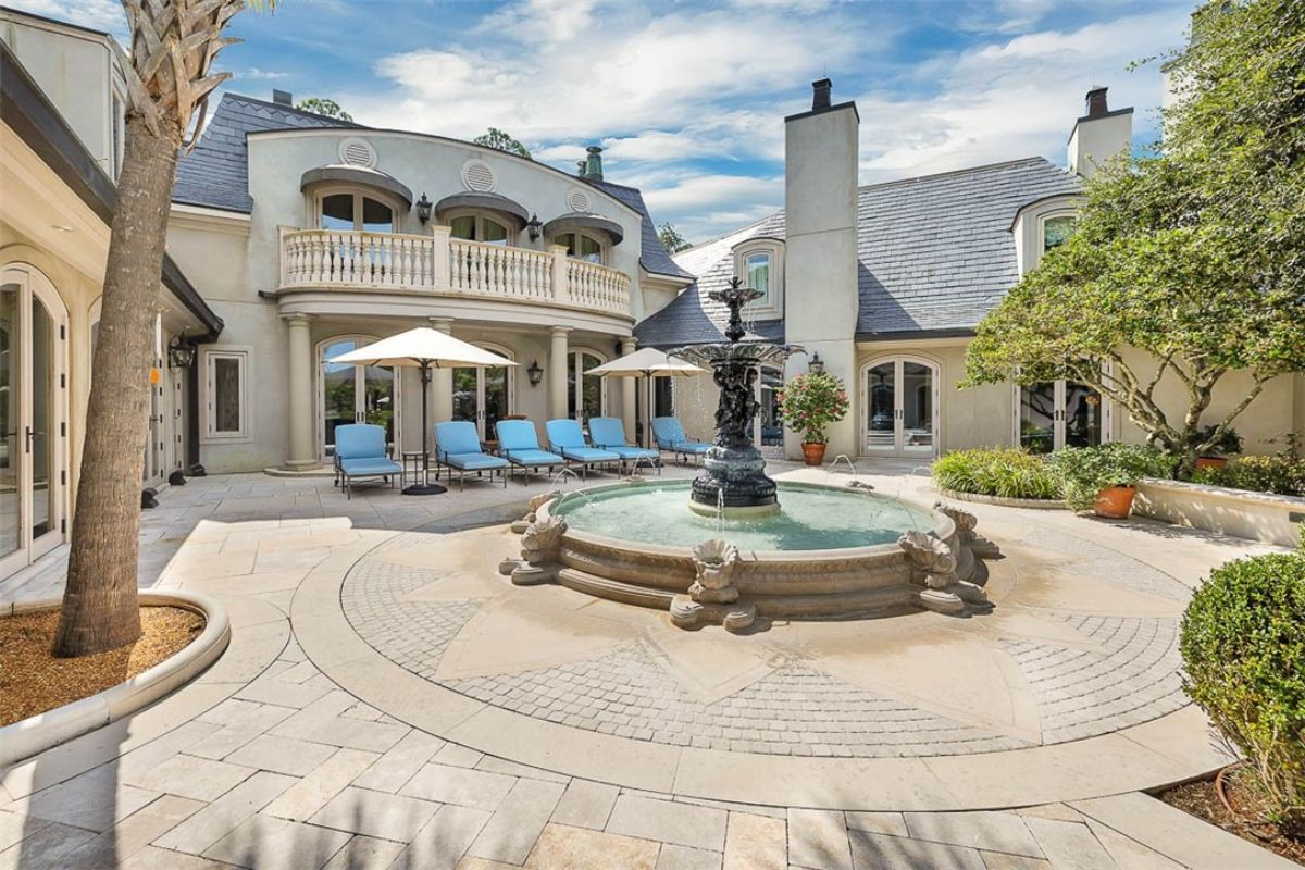 Front yard water fountain and blue benches. 