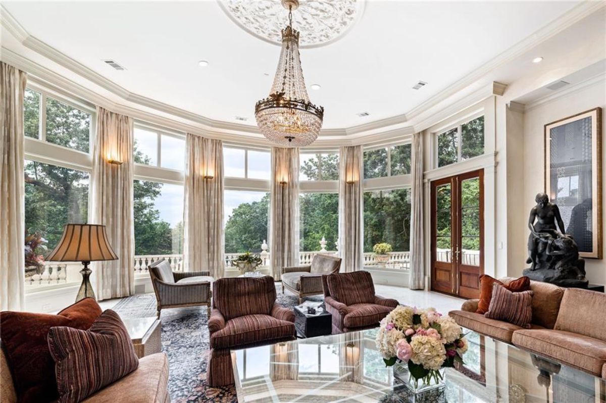 Living room with a chandelier and glass windows. 