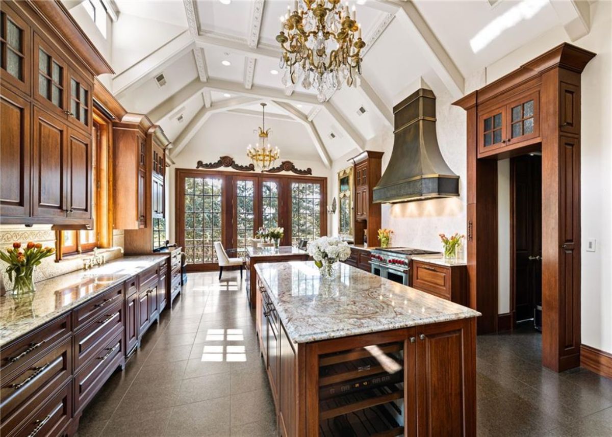 Kitchen with a large island, chandelier and custom cabinets. 