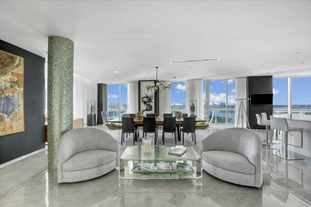 A well-organized great room, with stylish decor, features large glass windows