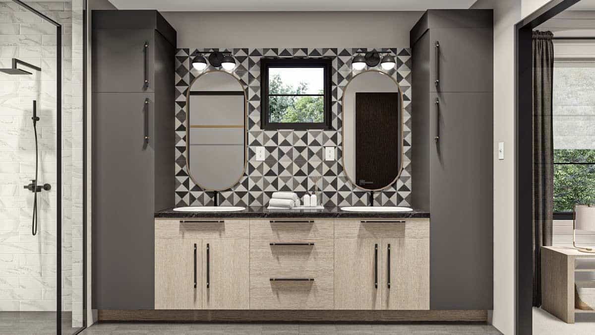 Primary vanity with two sinks and oval mirrors mounted against the decorative-tiled backsplash.