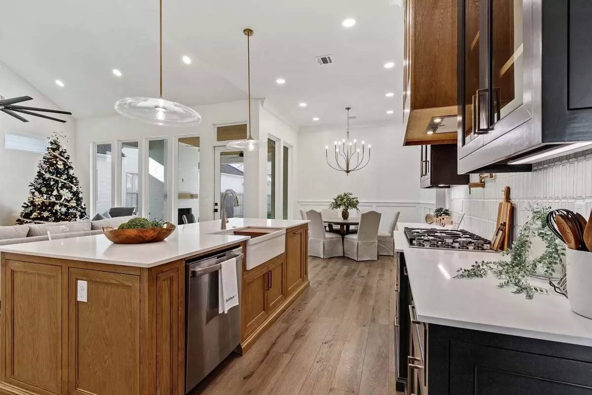 The kitchen includes a built-in cooktop and a farmhouse sink fitted on the breakfast island.