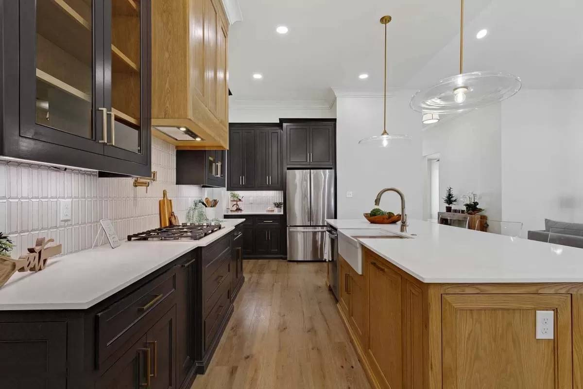 Recessed ceiling lights and glass pendants over the island illuminate the kitchen.