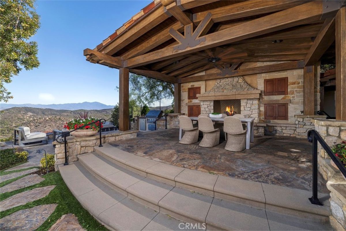 An outdoor dining area with a fireplace.