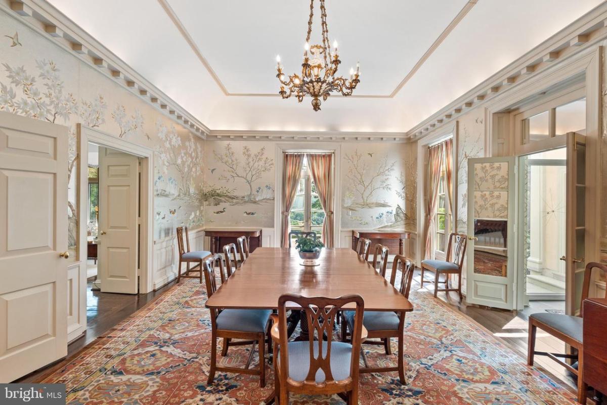 Dining room with a chandelier and a large rug.