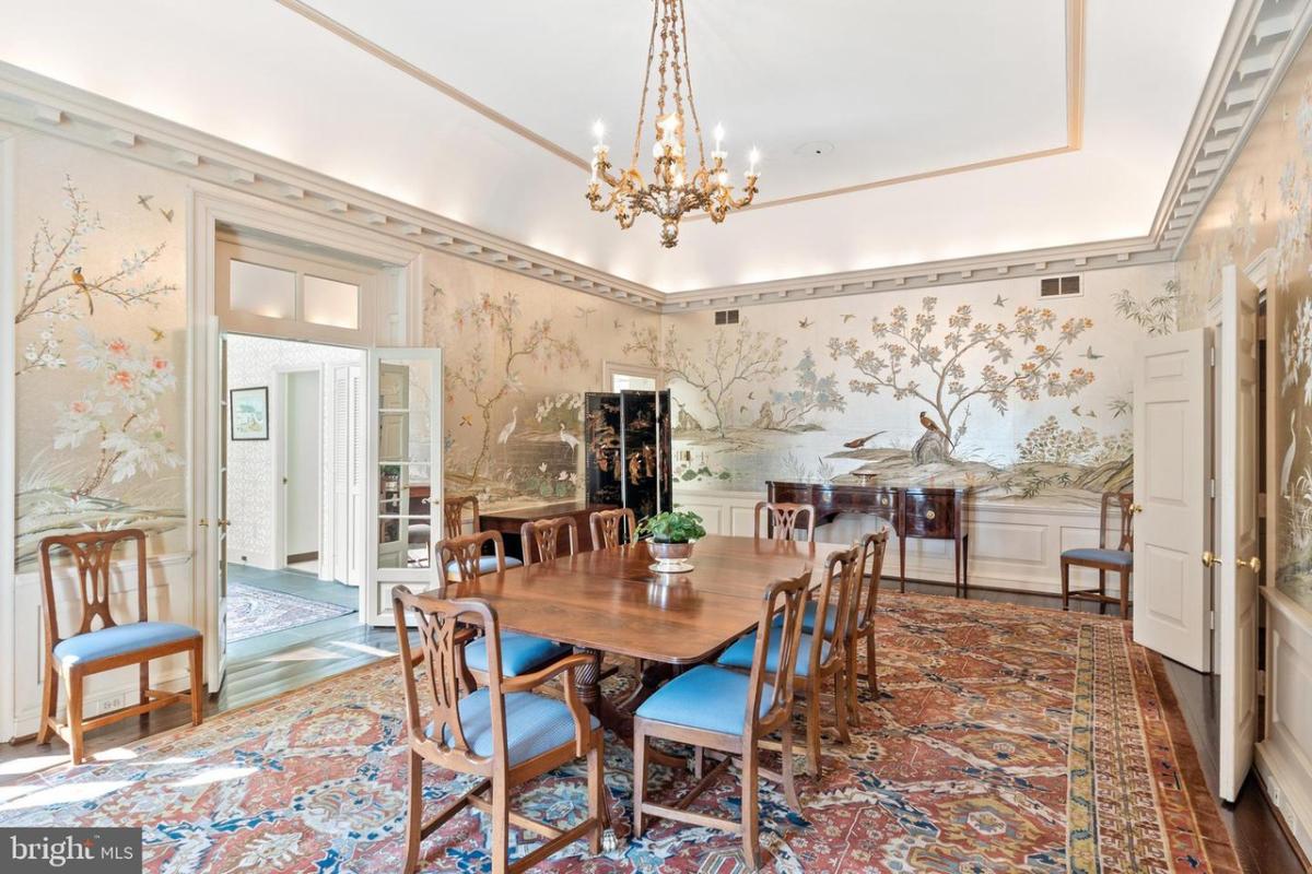 Dining room with a chandelier and a large rug.