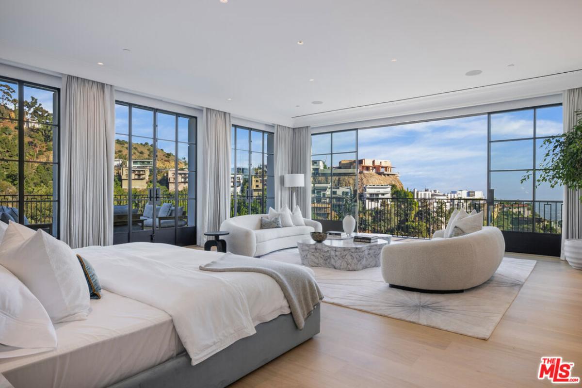 Bedroom with a large bed, sliding glass doors and a balcony.