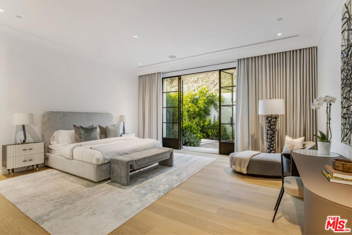 Bedroom with a large bed and wood flooring.