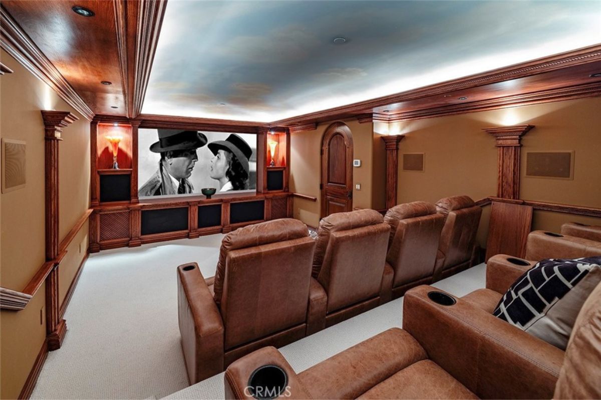 A home theater with brown couches and walls.