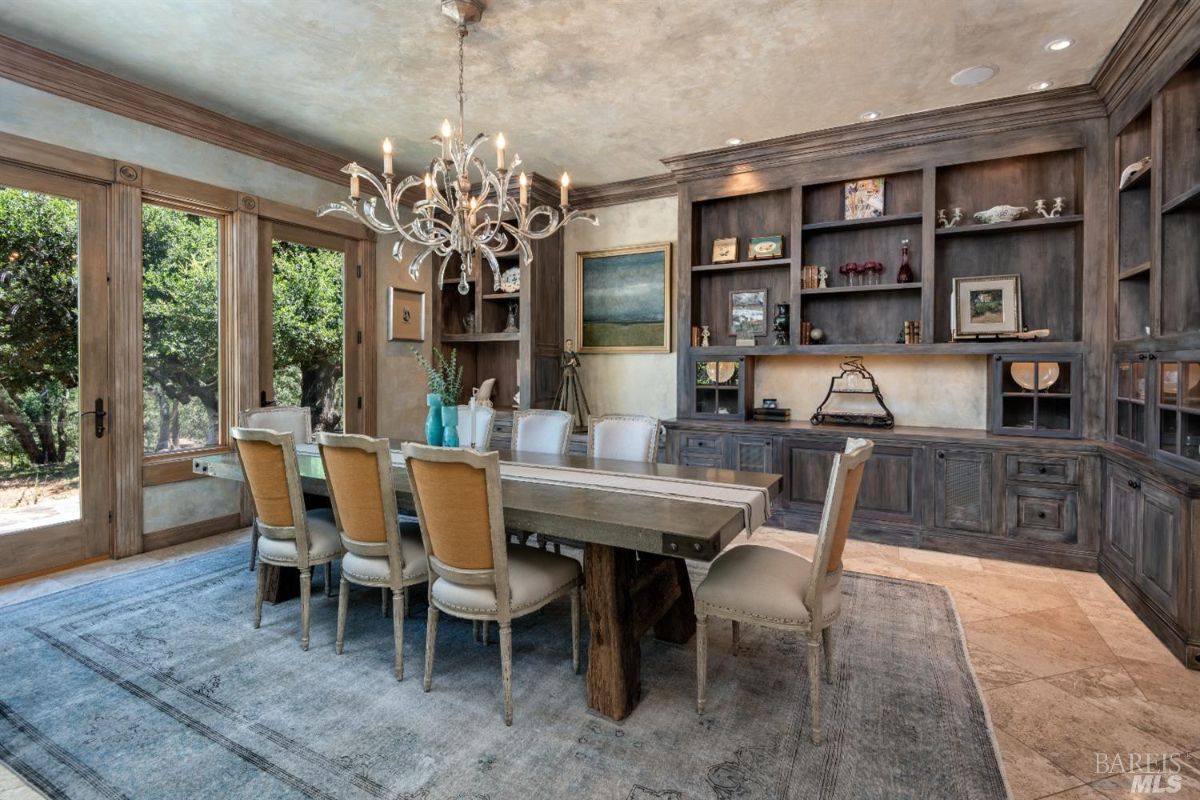 Dining room with a large table and a chandelier.