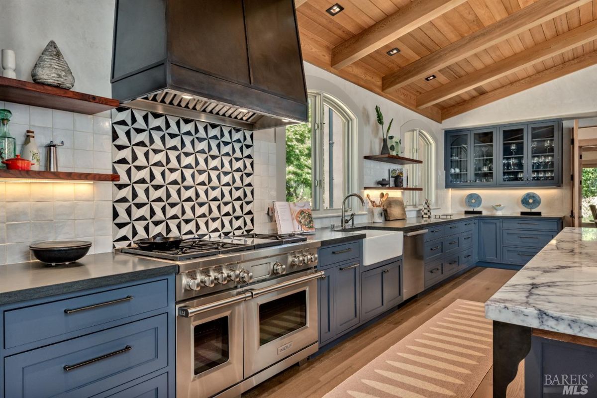 Kitchen with wood flooring, open beam ceiling and custom cabinets.