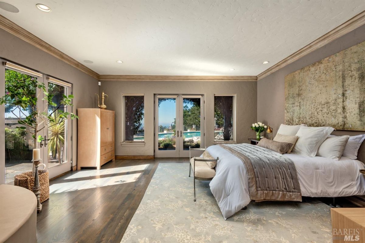 Bedroom with a large bed, custom lights and glass doors.