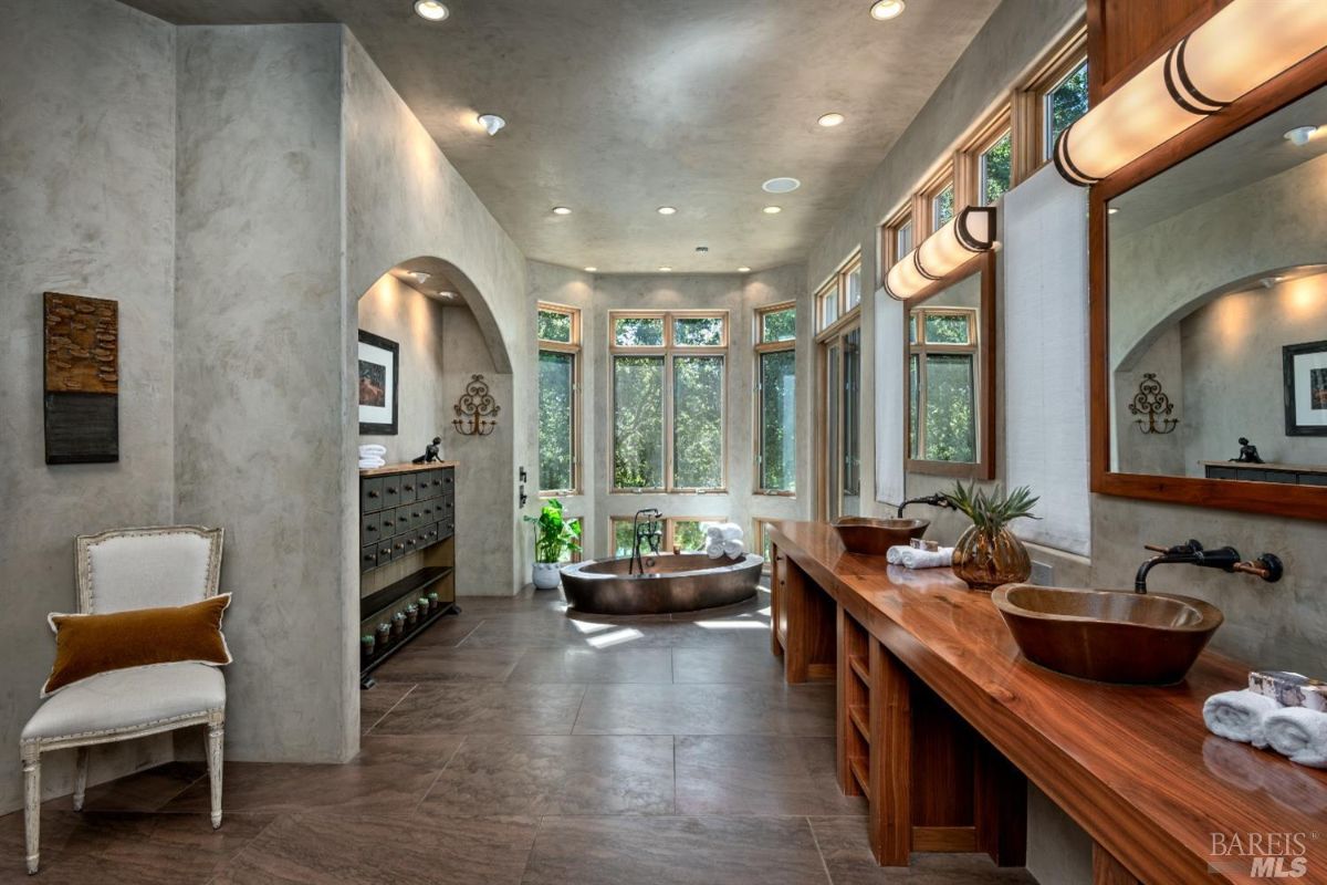 Bathroom with a soaking tub, sinks and custom lights.