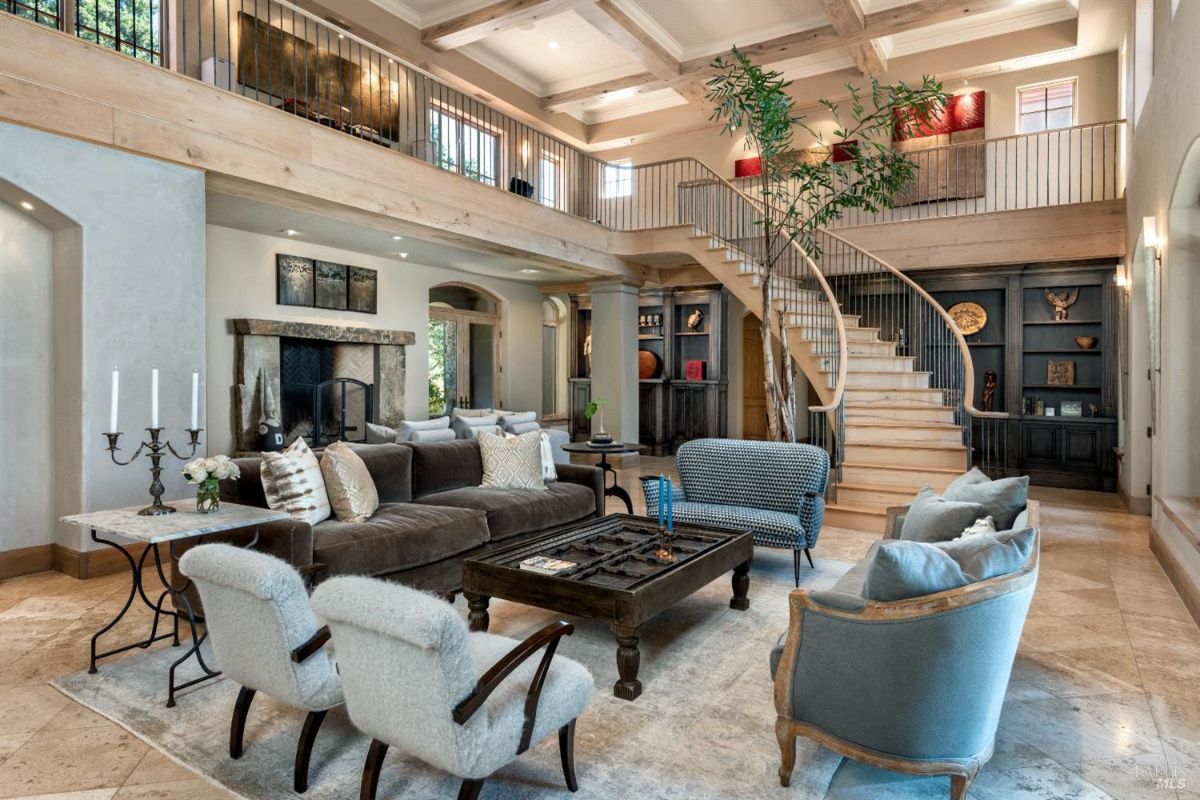 Living room with couches, fireplace and a staircase.