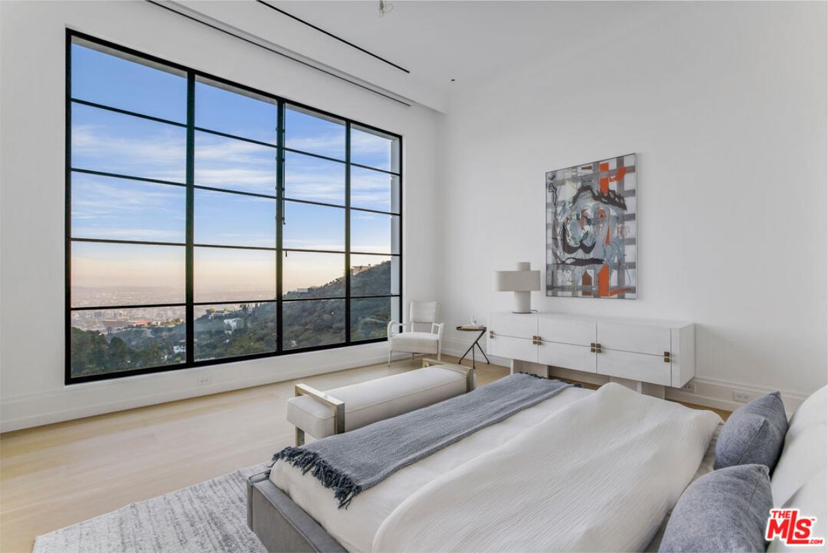 Bedroom with wood flooring and large glass windows.