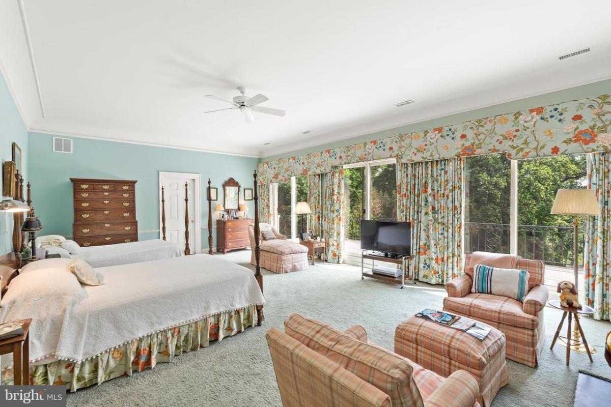 Bedroom with two beds, carpet flooring and sliding glass doors.