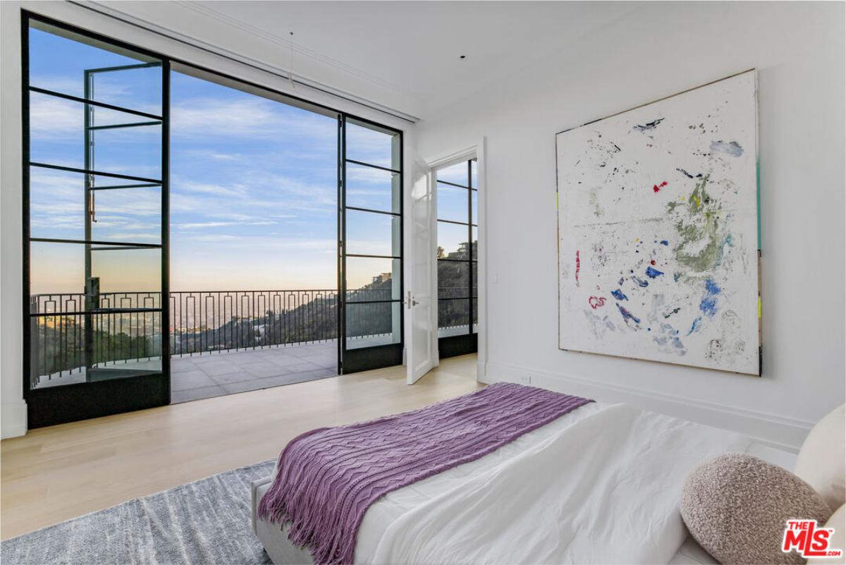 Bedroom with wood flooring and large glass doors.