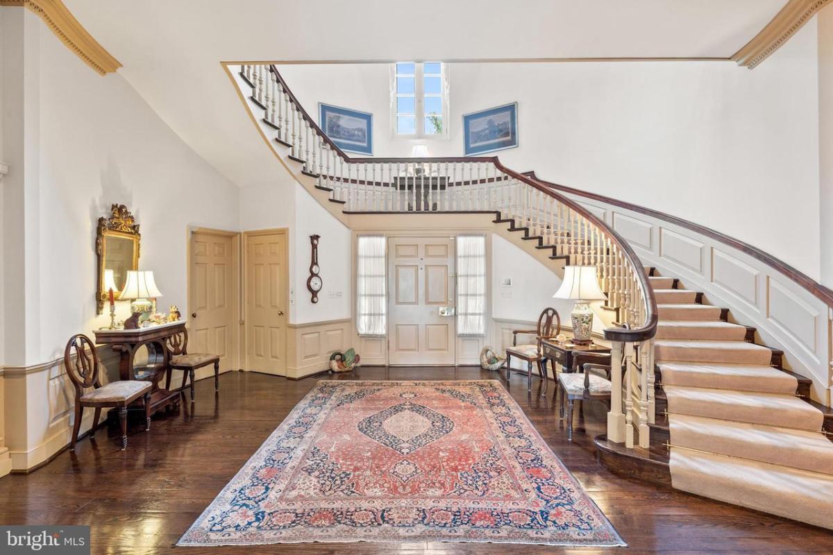 Foyer with wood flooring and stairs.