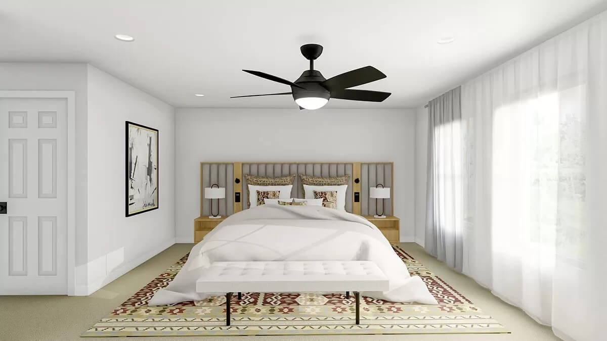 Primary bedroom with a platform bed and a tufted bench over the large area rug.