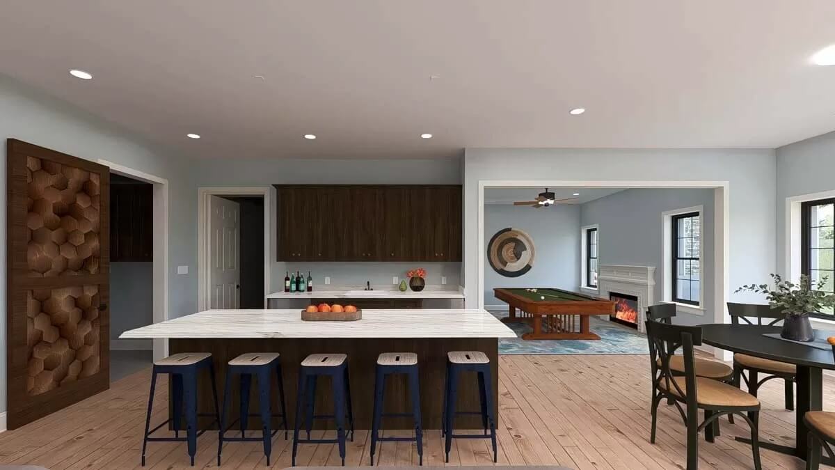 Lower-level kitchen with dark wood cabinets, marble countertops, and a breakfast island.