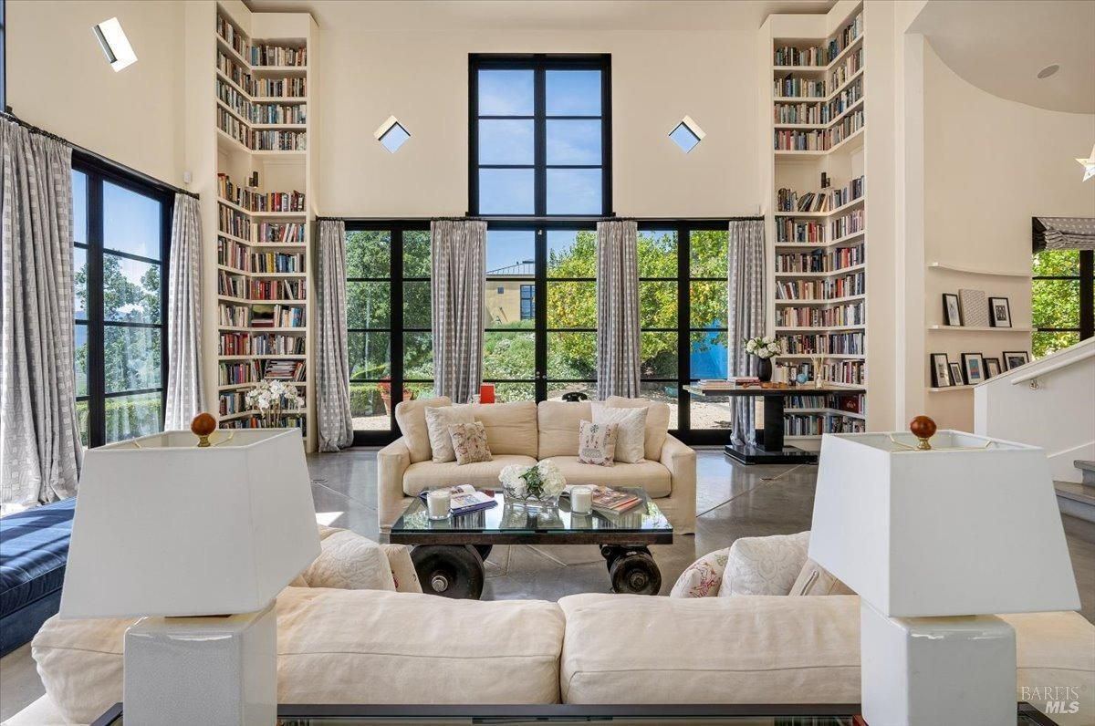 Living room with couches and glass windows.