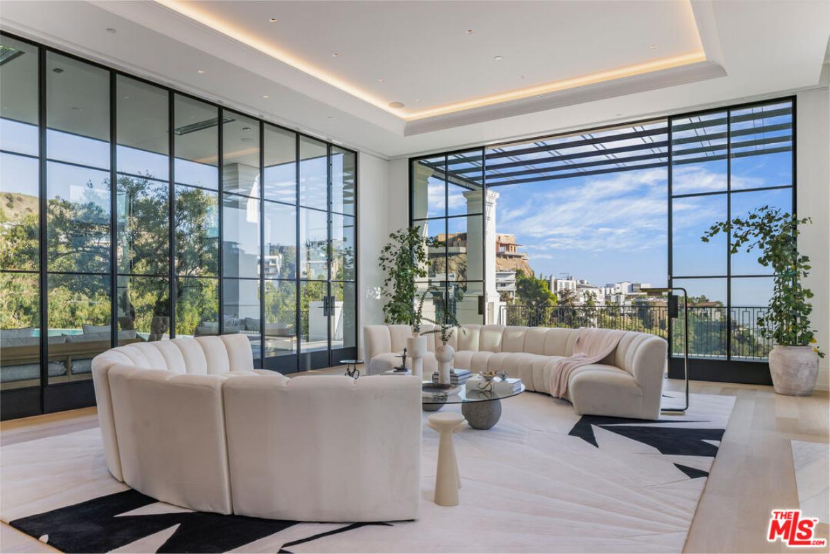 Living room with couches and glass walls.