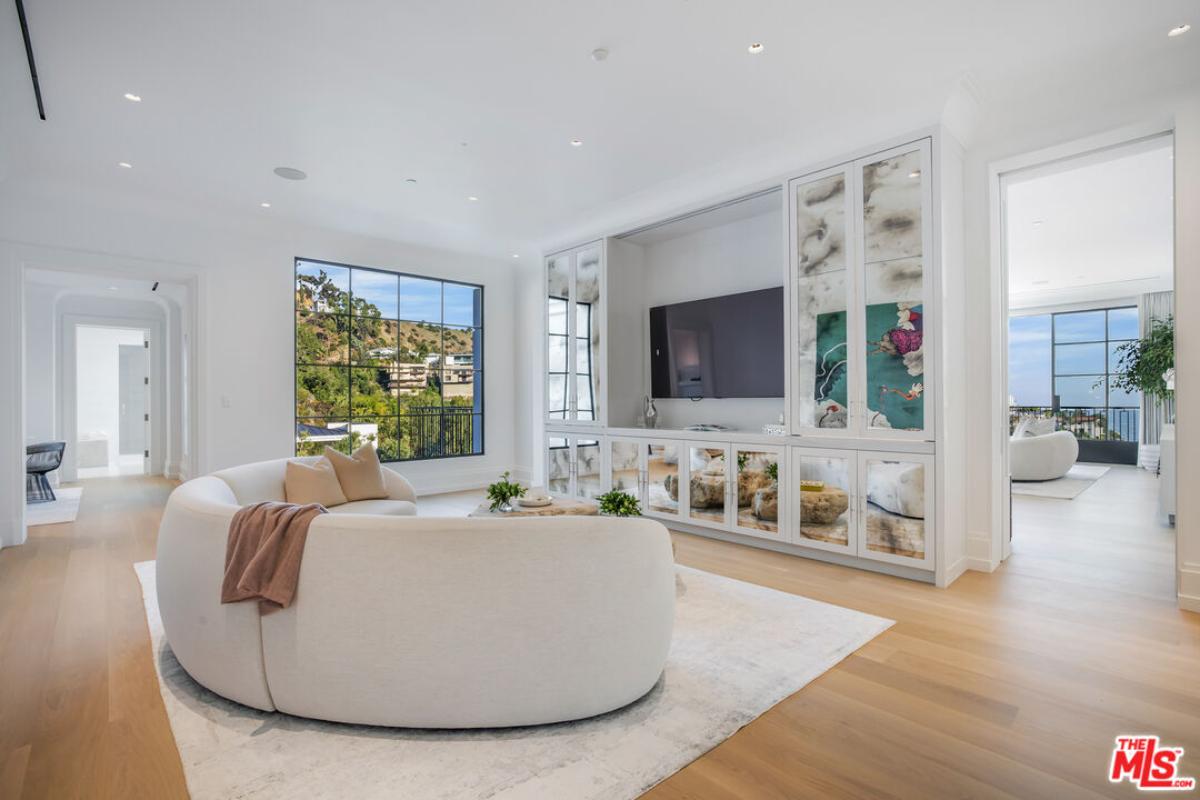 Family room with couches, wood flooring and a TV.