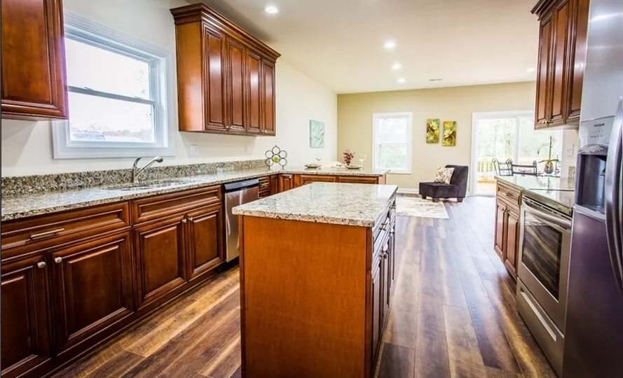 Kitchen with wooden cabinetry, granite countertops, and a center island.