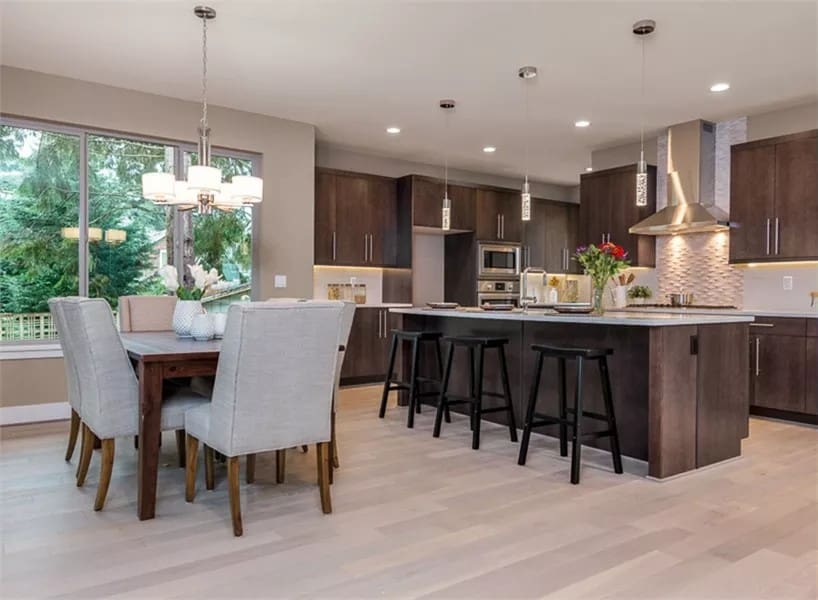 Kitchen and dining area brightened by a trio of windows overlooking the backyard.