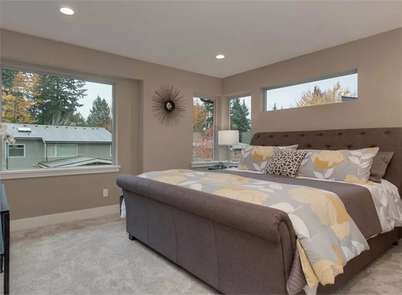 Primary bedroom with a tufted bed over the carpeted floor.