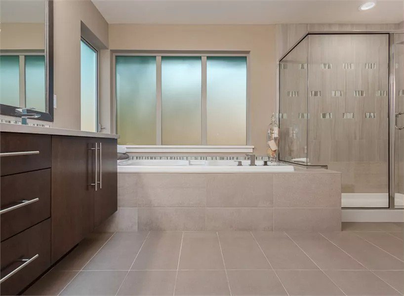 Primary bathroom with a wooden vanity, a drop-in tub, and a walk-in shower.