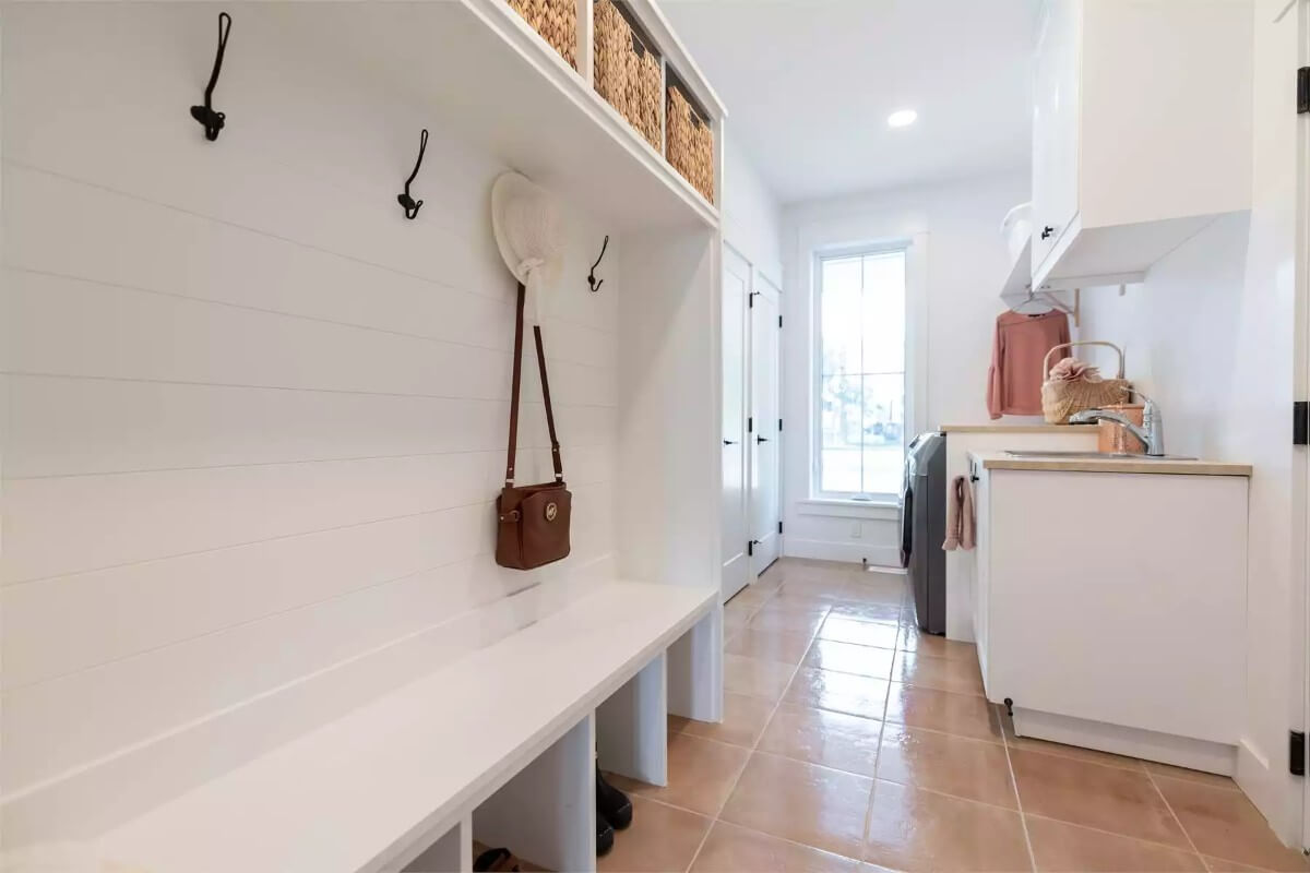 Mudroom with built-in cubbies, a bench, and coat hooks.