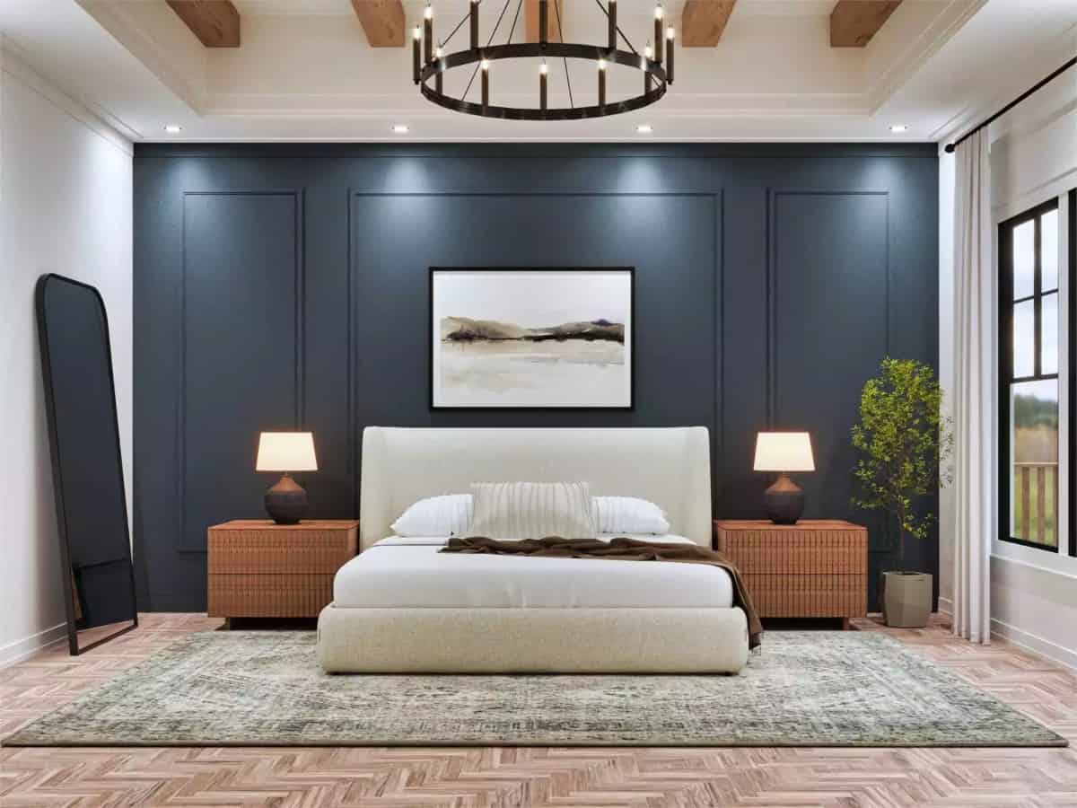 Primary bedroom with a blue accent wall and a tray ceiling accentuated with exposed wood beams.