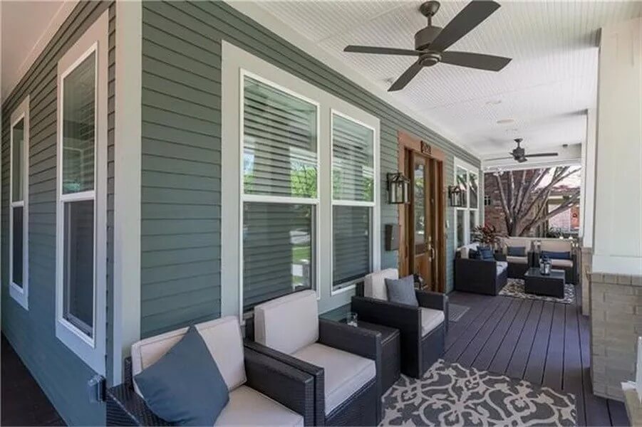 Front porch with wicker seats over the wide plank flooring.