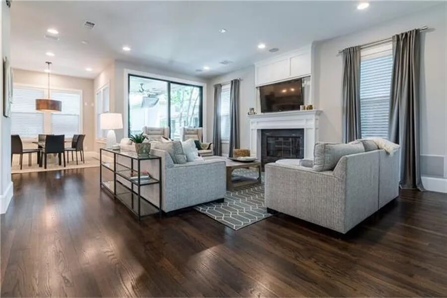 Family room with gray sofas and a fireplace topped by a TV.