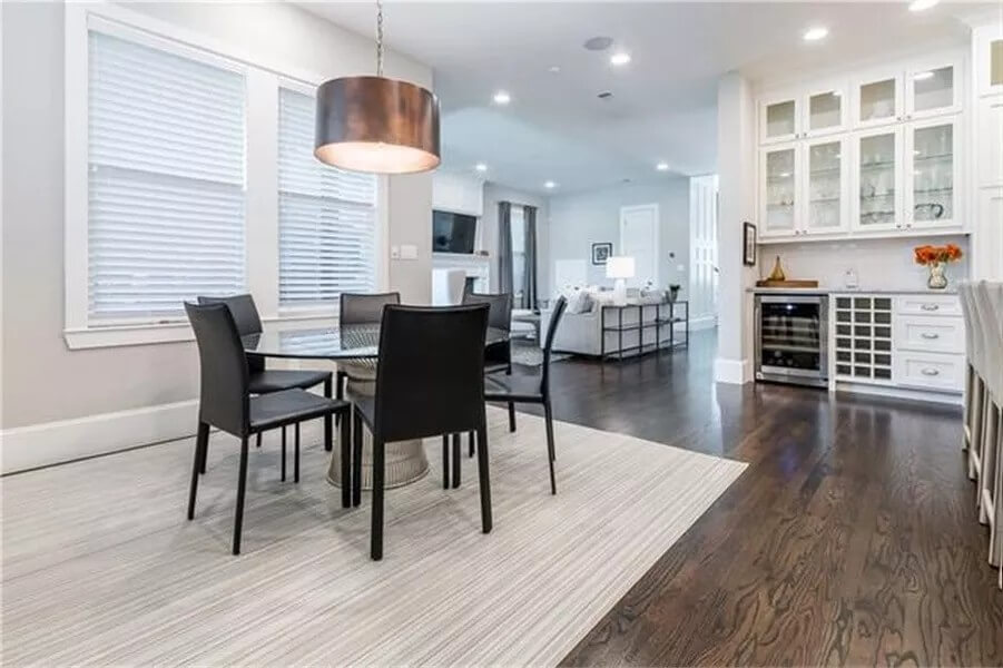 Breakfast nook with a round dining set illuminated by a drum pendant.