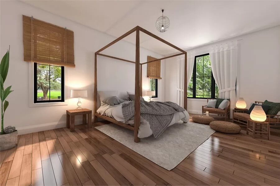 Primary bedroom with a canopy bed and a sitting area with cushioned armchairs.